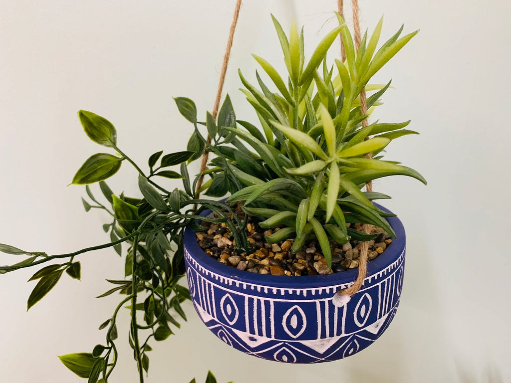 Blauer Keramik-Hängetopf mit Pflanzen